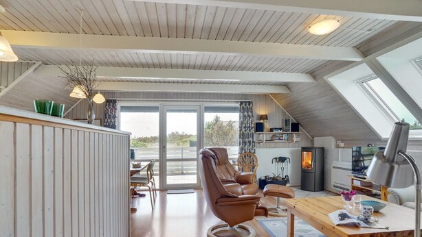 A cozy attic room with a wooden ceiling, a comfortable leather chair, a wooden table, and a fireplace. - "Alleta" - 600m from the sea by Interhome (Ringkøbing)