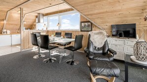 Un interior acogedor de madera con comedor, televisor y chimenea.
