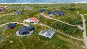 Vista aérea de una comunidad costera con casas y una playa.