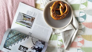 Un llibre amb una fotografia d'una escala, un bol amb un torró salat i un teixit estampat.