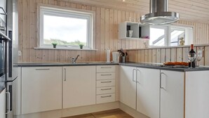 Moderni keittiö, jossa on puupanelointi, ikkuna ja sisäänrakennetut kaapit.