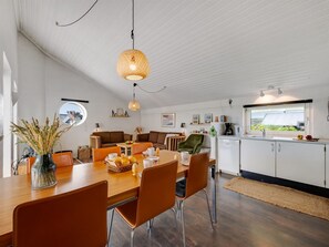 Une cuisine moderne avec un coin repas, un plancher en bois et une vue par la fenêtre.