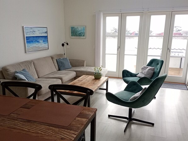 A modern living room with a sofa, chairs, a coffee table, and a view through large glass doors. - "Ingeborre" - 100m to the fjord by Interhome (Vestervig)