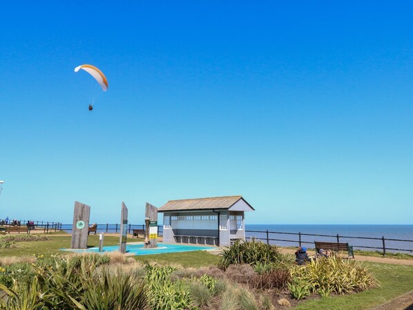 A coastal building with a swimming pool, surrounded by greenery and a clear view of the sea. - 31 Siesta Mar Chalet Park (Norwich)
