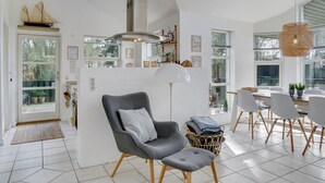 Un espacio habitable amplio con una cocina moderna, comedor y un gran ventanal que proporciona luz natural.