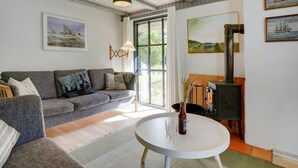 Een gezellige woonkamer met een bank, een ronde tafel en een open haard.