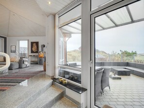 A modern interior with a stone staircase leading to a balcony.