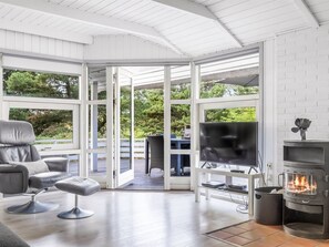 A modern living room with a fireplace, a TV, and a comfortable seating area.