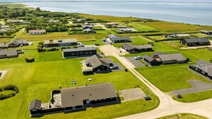 An aerial view of a residential area with houses, green lawns, and a body of water in the background. - "Samuil" - 300m to the fjord by Interhome (Vinderup)