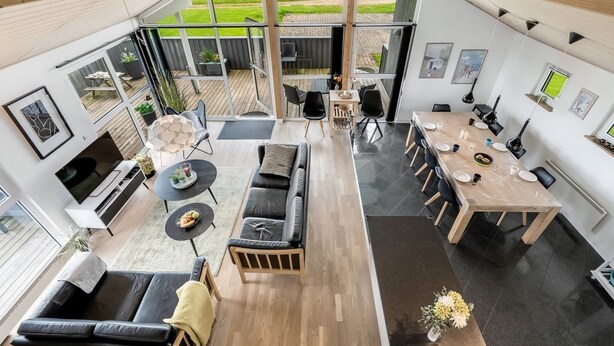 A modern interior with a dining area, a sofa, a TV, and a view of the outdoors. - "Samuil" - 300m to the fjord by Interhome (Vinderup)