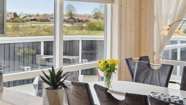 Un espace repas avec vue sur une terrasse et des maisons.