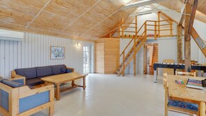 A spacious loft with a high ceiling, wooden beams, a loft bed, a sofa, a dining table, and a staircase. - "Answald" - 250m from the sea by Interhome (Harboøre)