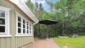 Un bâtiment doté d’un patio, d’un espace extérieur aménagé avec des sièges et de plantes en pot.