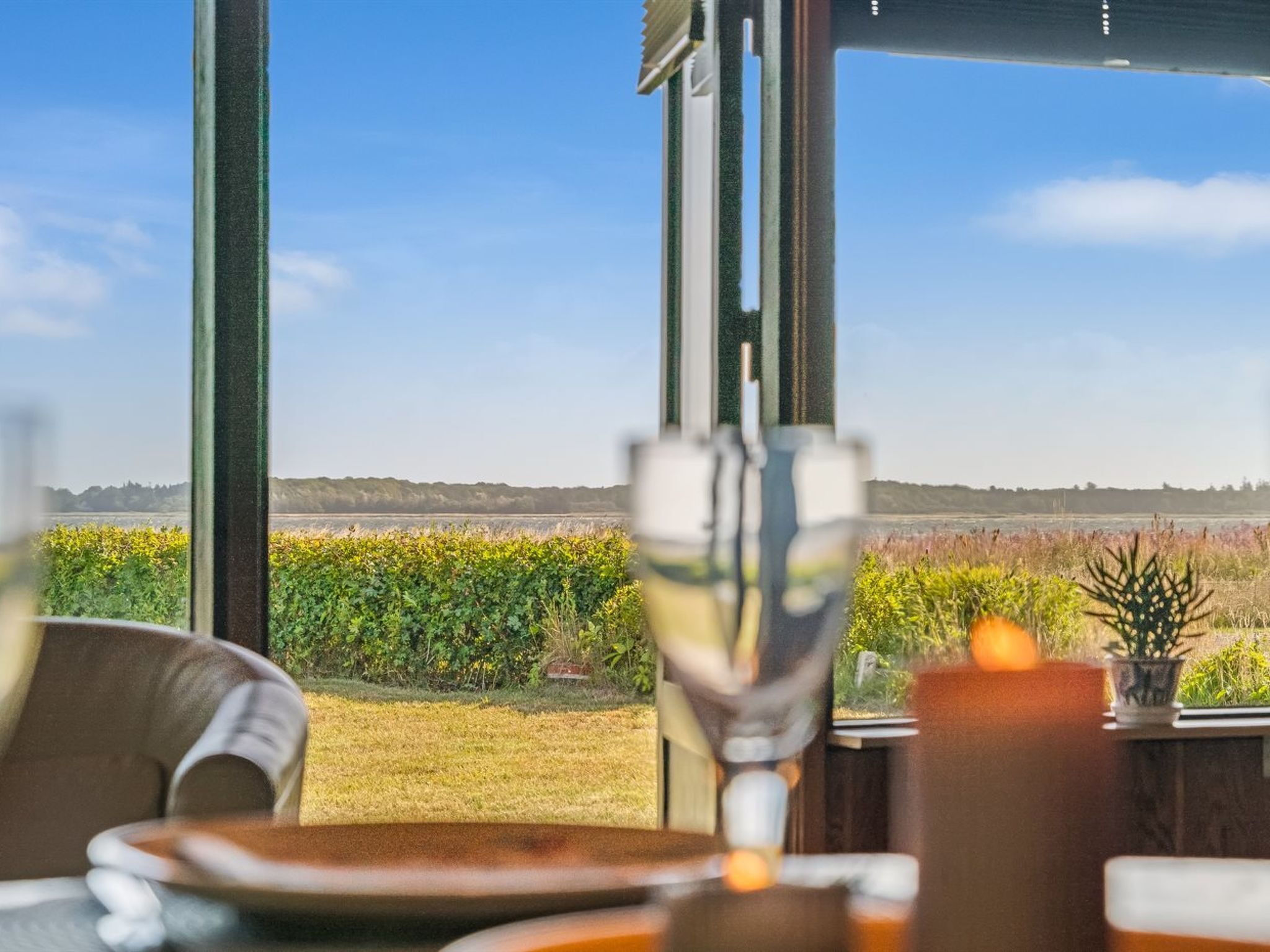 A dining area with a view of a field and trees.