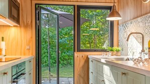 A modern kitchen with a large window, wooden cabinets, and a sink. - "Tayana" - 75m to the fjord by Interhome (Storvorde)