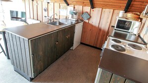A compact kitchen with a central island, a sink, a microwave, and a stove. - "Keijo" - 1.5km from the sea by Interhome (Fanø)