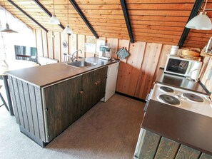 Kjøleskap, mikrobølgeovn, ovn og høy barnestol