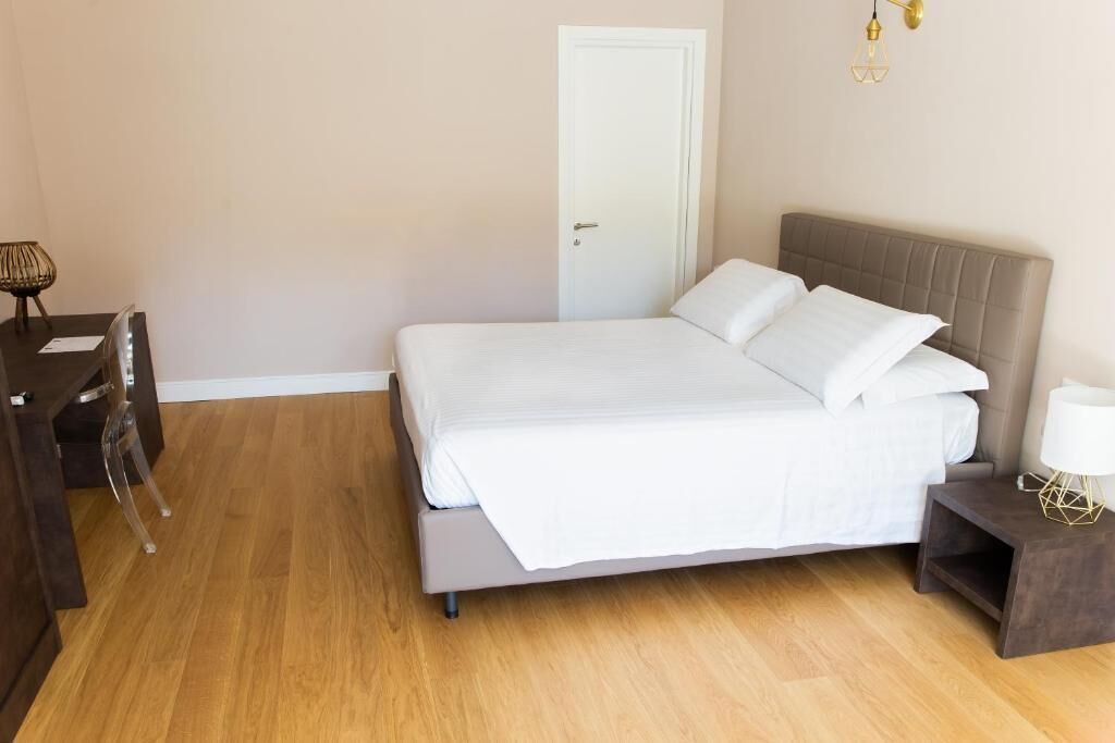 Un dormitorio con cama, escritorio y silla.