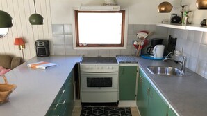 A compact kitchen with a stove, sink, and a window above the countertop. - "Harald" - 300m from the sea by Interhome (Idestrup)