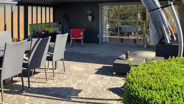 An outdoor patio with wicker furniture, a red chair, and a green toy truck. - "Harald" - 300m from the sea by Interhome (Idestrup)
