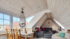 Un loft spacieux comprenant un coin repas, un canapé et une cuisine.
