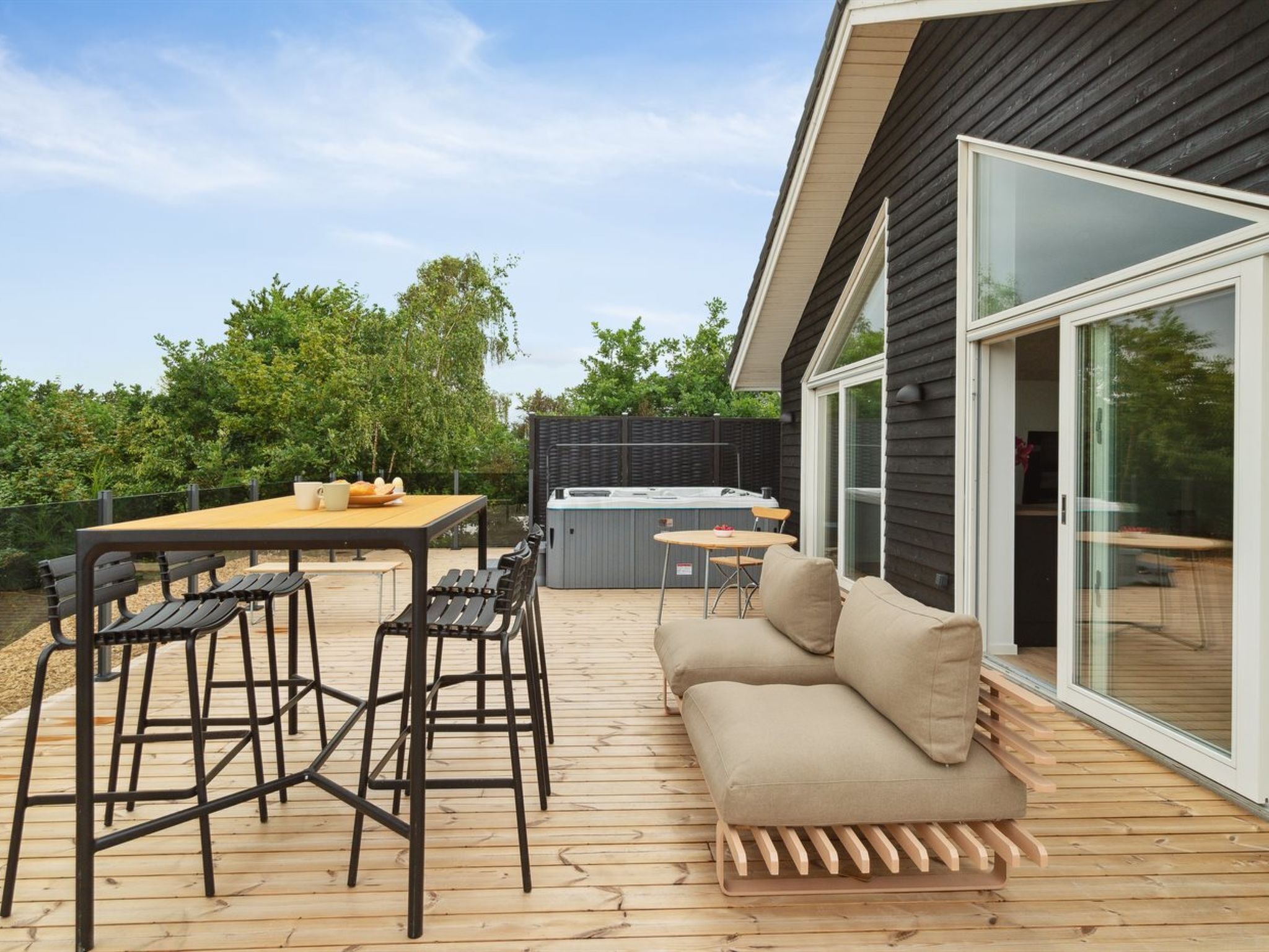 A deck with a table, chairs, and a sofa.