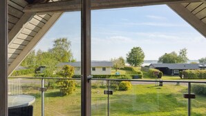 Un balcón con vistas a una zona residencial, con casas y vegetación.