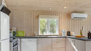 Une cuisine moderne avec des murs recouverts de panneaux en bois, une grande fenêtre et des appareils électroménagers intégr és.