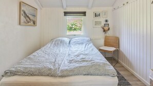 A bedroom with a bed, a window, and a chair. - "Weland" - 800m from the sea by Interhome (Løkken)