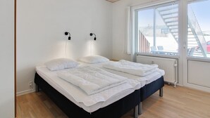 A modern bedroom with a wooden ceiling, a large window with blinds, and a bed with white bedding. - "Haghni" - 200m from the sea by Interhome (Løkken)