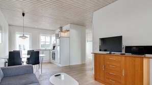 A modern living room with a grey sofa, a white coffee table, and a wooden cabinet with a flat-screen TV. - "Haghni" - 200m from the sea by Interhome (Løkken)