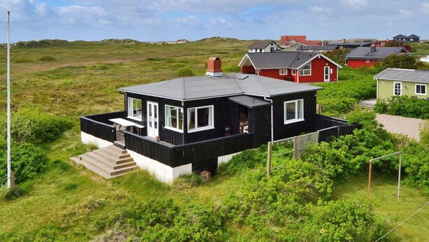 Une maison moderne avec un toit plat, de grandes fenêtres et une petite terrasse.