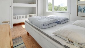Une chambre avec un lit superposé, un lit simple, une fenêtre avec vue et un luminaire suspendu.