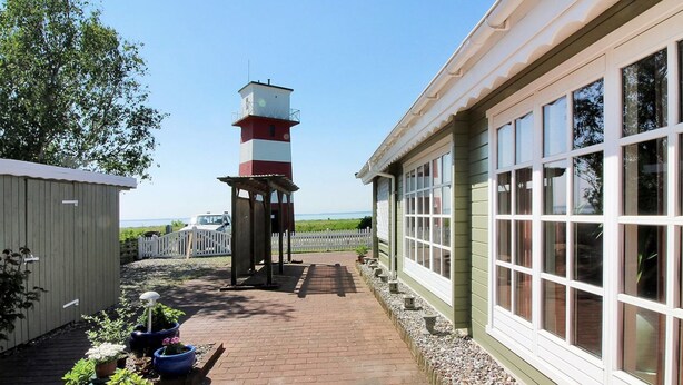 A pathway leading to a lighthouse, a building with large windows, and potted plants. - "Enrik" - 123m from the sea by Interhome (Vordingborg)