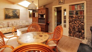 A cozy room with a round table, wicker chairs, a sofa, a bookshelf, and a fireplace. - "Enrik" - 123m from the sea by Interhome (Vordingborg)