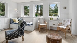 A bright, white room with a bed, two wicker chairs, a small table, and a window seat. - "Asla" - 400m from the sea by Interhome (Hals)