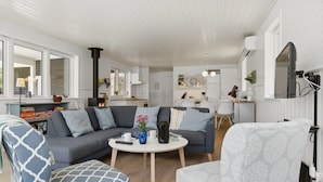 A modern living room with a grey sectional sofa, a patterned armchair, and a round coffee table. - "Asla" - 400m from the sea by Interhome (Hals)