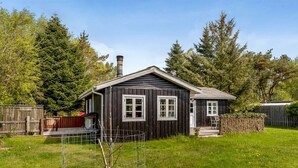 A wooden cabin with a fenced yard, a chimney, and a small garden area. - "Ingobert" - 50m from the sea by Interhome (Hals)