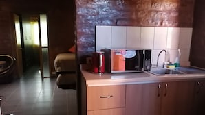 Una cocina moderna con microondas integrado, un lavamanos y armarios de madera.
