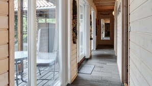 Un couloir en bois avec des portes en verre donnant sur un patio.