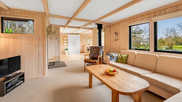 A modern interior with wooden paneling, a sofa, a coffee table, and a TV. - "Scarlet" - 400m to the fjord by Interhome (Vinderup)
