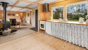 A cozy cabin interior with a wooden interior, a kitchen with a large window, and a fireplace. - "Scarlet" - 400m to the fjord by Interhome (Vinderup)