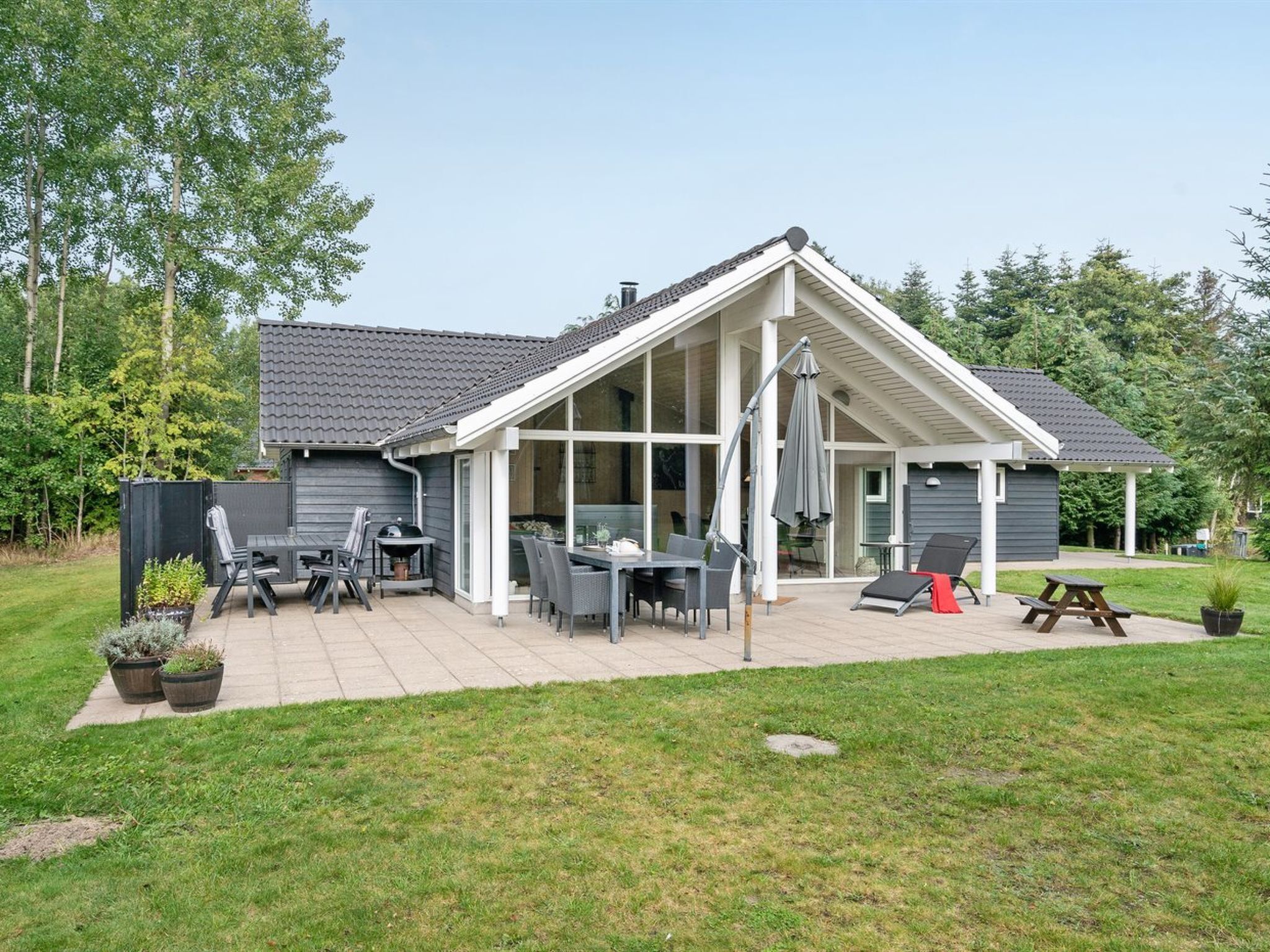 A house with a patio, outdoor seating, and a covered area.