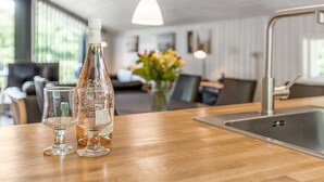 A modern kitchen with a wooden countertop, a stainless steel sink, and a bottle of wine. - "Corinna" - 28km from the sea by Interhome (Toftlund)