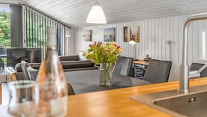 A modern kitchen with a wooden countertop, a vase of flowers, and a dining area with a table and chairs. - "Corinna" - 28km from the sea by Interhome (Toftlund)