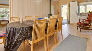 A cozy wooden interior with a dining table, chairs, and a rocking chair. - "Alisia" - 400m from the sea by Interhome (Hals)
