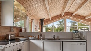 A modern kitchen with wooden beams, a large window, and a coffee maker. - "Jannus" - 550m from the sea by Interhome (Hals)
