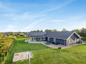 Une maison moderne dotée d’un grand patio et d’une piscine.