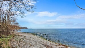 A rocky shoreline with a clear view of the sea and a distant landmass. - "Alfred" - 25m from the sea by Interhome (Gudhjem)