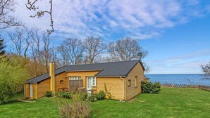 A wooden cabin with a sloped roof, a small porch, and a view of the sea. - "Alfred" - 25m from the sea by Interhome (Gudhjem)